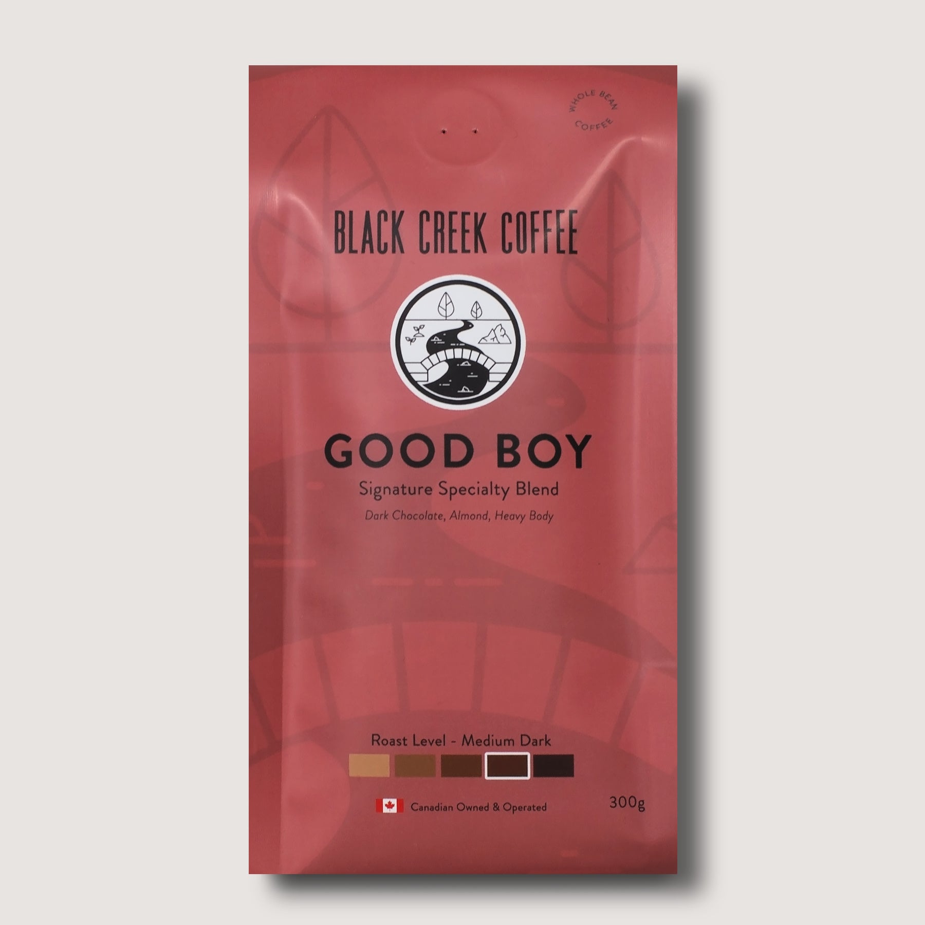 Red coffee package labeled 'Black Creek Coffee Good Boy' on a light gray background