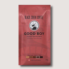 Red coffee package labeled 'Black Creek Coffee Good Boy' on a light gray background