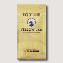Yellow package of Black Creek Coffee Yellow Lab espresso blend on a light gray background